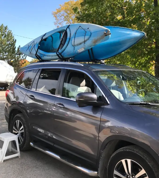 Forester holding two kayaks on TMS brand kayak roof rack 